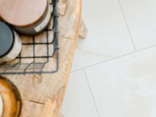 Close-up of bathroom accessories on a tray next to the herringbone tile floor.