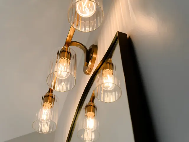 Glass-shaded vanity lights with gold-tone fittings above an arched mirror.