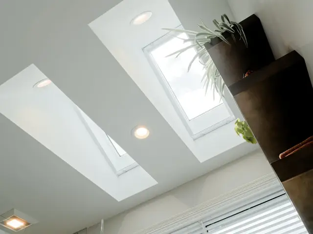 Two skylights and recessed ceiling lights above the bathroom window and shelving.