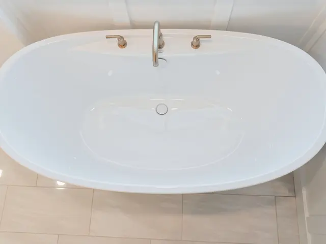 Overhead view of the white freestanding tub with centered gold-tone faucet.