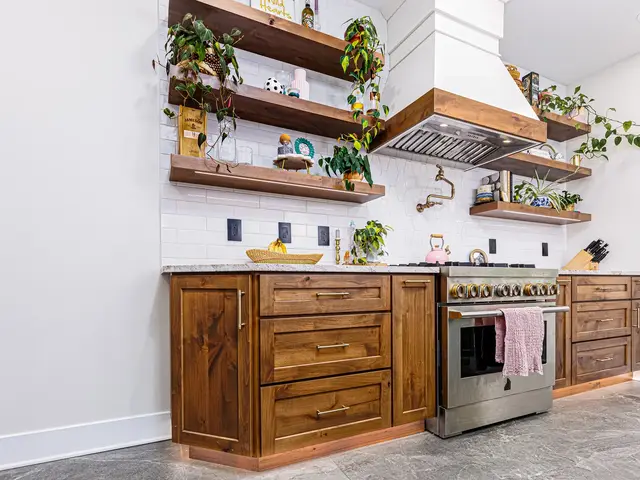 Cooking wall with a stainless range, wood cabinets, white backsplash and floating wood shelves.