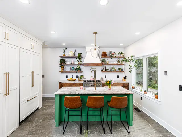 Front view of the green island with three woven stools beneath pendant lights and white ceiling.